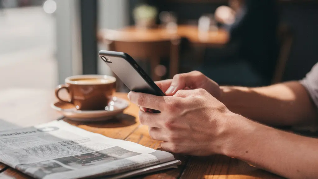 Mains tenant un smartphone montrant une carte avec des épingles de restaurants, vue de dessus